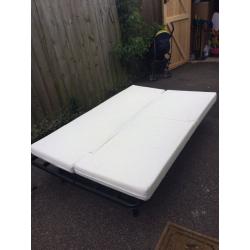 Futon sofa bed with mattress. Two adults can comfortably sleep on it. White fabric. Metal frame