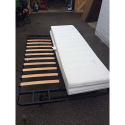 Futon sofa bed with mattress. Two adults can comfortably sleep on it. White fabric. Metal frame